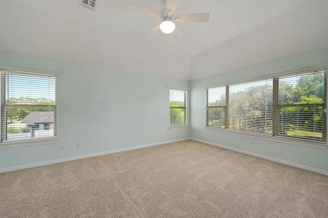 spare room featuring light carpet, ceiling fan, and vaulted ceiling