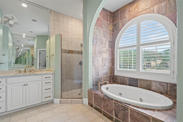 bathroom featuring tile patterned floors, vanity, separate shower and tub, and tile walls