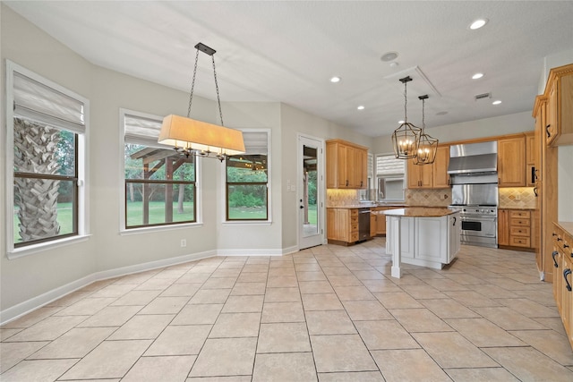 kitchen featuring a center island, backsplash, wall chimney exhaust hood, decorative light fixtures, and stainless steel appliances