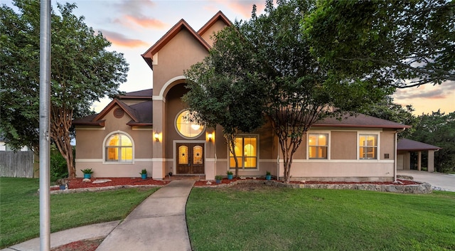 view of front of house with french doors, a carport, and a lawn