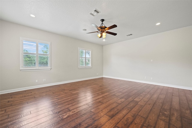 spare room with a textured ceiling, ceiling fan, and dark wood-type flooring