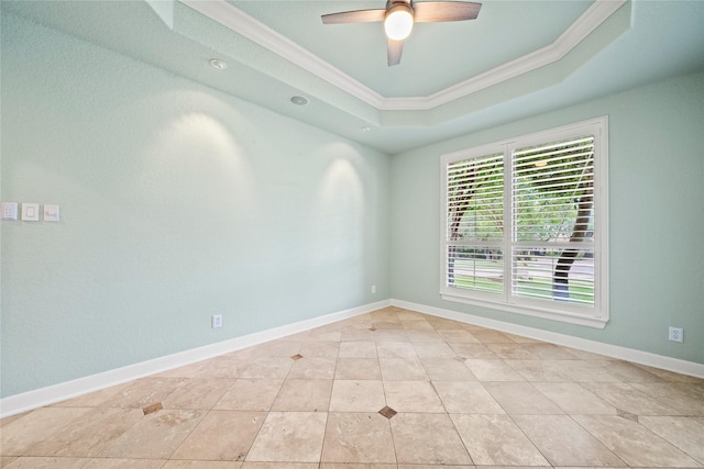 tiled empty room with a tray ceiling, ceiling fan, and ornamental molding