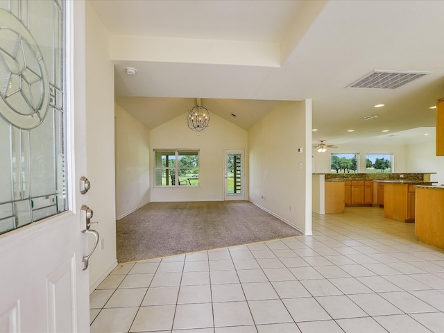 carpeted foyer with ceiling fan with notable chandelier