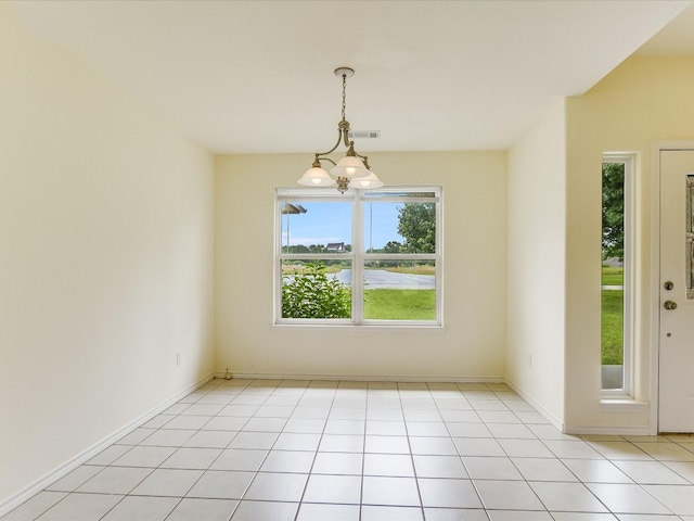 empty room featuring a notable chandelier and light tile floors