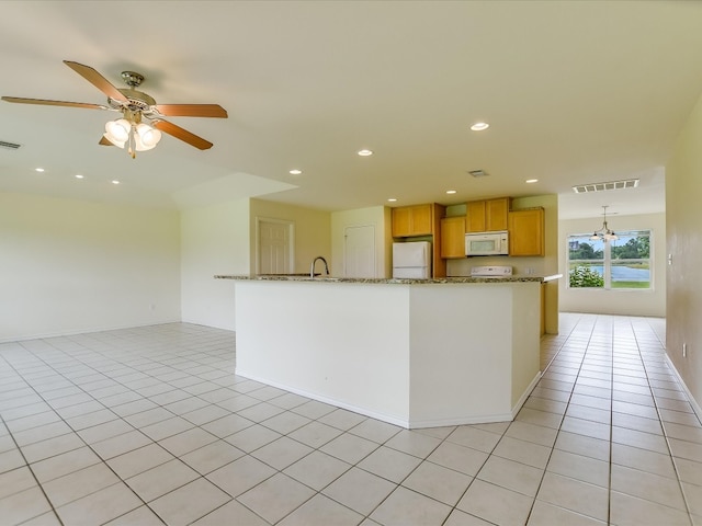 kitchen featuring ceiling fan, white appliances, a center island with sink, light tile flooring, and sink