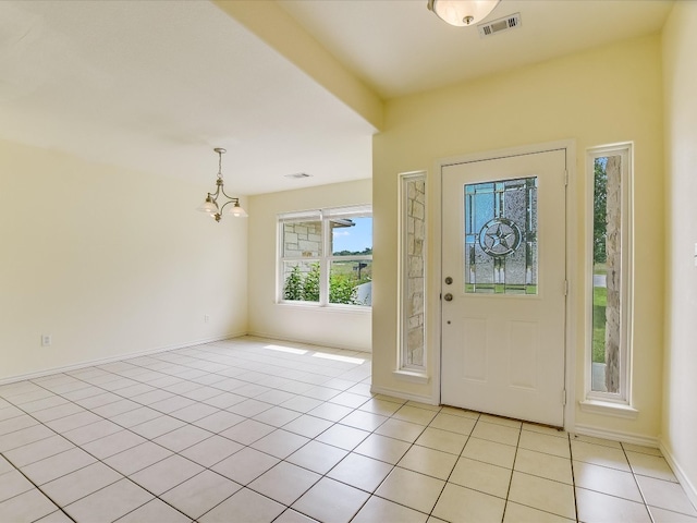 tiled entryway featuring a chandelier