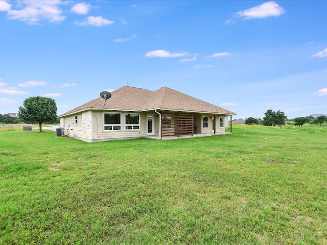 back of property with central AC and a yard