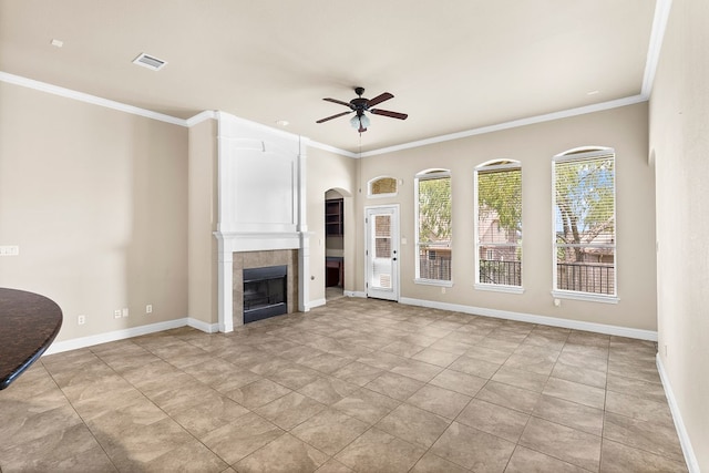 unfurnished living room featuring a fireplace, crown molding, and ceiling fan