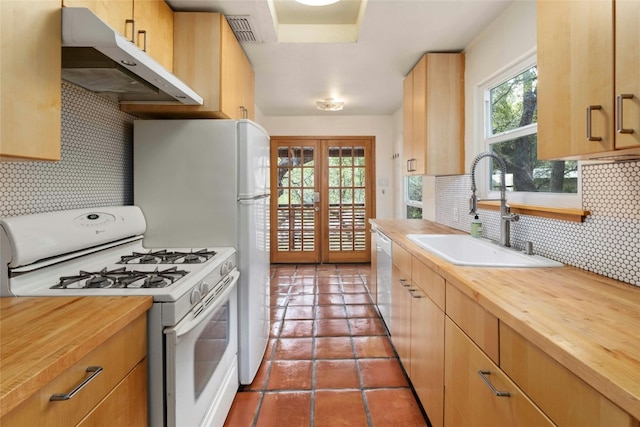 kitchen featuring gas range gas stove, wooden counters, french doors, stainless steel dishwasher, and sink