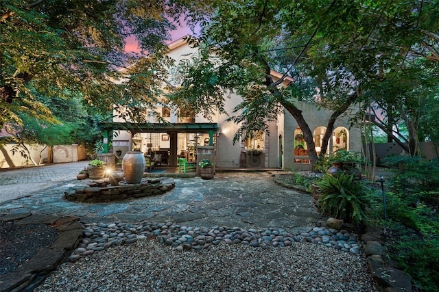 back house at dusk with a patio area