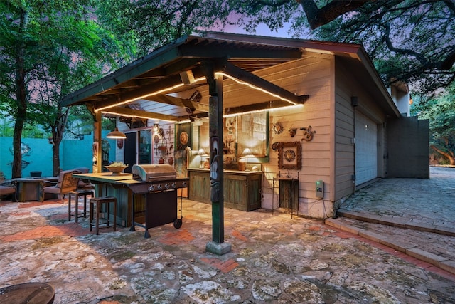 patio terrace at dusk featuring exterior kitchen and exterior bar