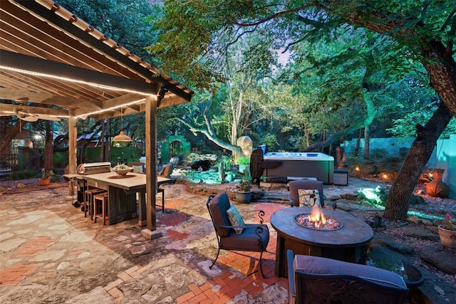 view of patio / terrace featuring a hot tub and an outdoor fire pit