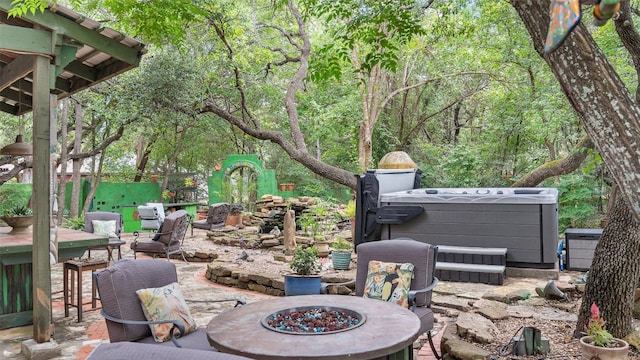 view of patio with a hot tub and a fire pit