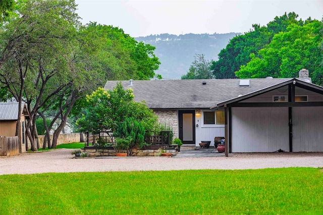 back of house featuring a yard and a mountain view