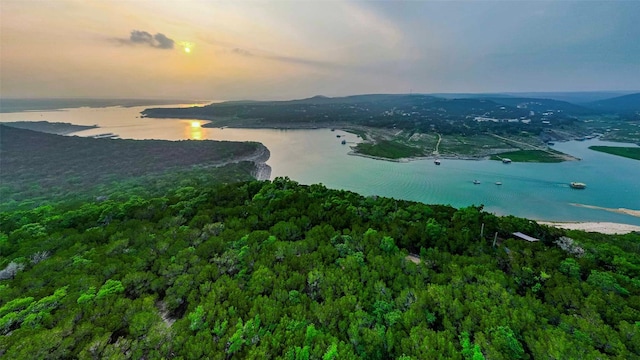 aerial view at dusk featuring a water view