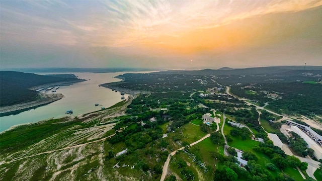 aerial view at dusk featuring a water view