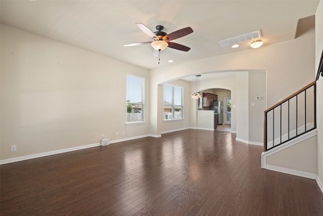 unfurnished living room featuring dark wood-type flooring and ceiling fan