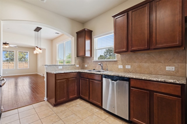 kitchen with light stone countertops, hanging light fixtures, ceiling fan, dishwasher, and light tile floors