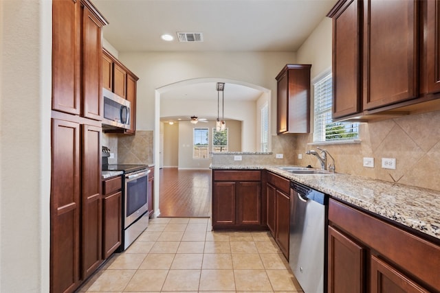 kitchen featuring stainless steel appliances, sink, a wealth of natural light, and ceiling fan