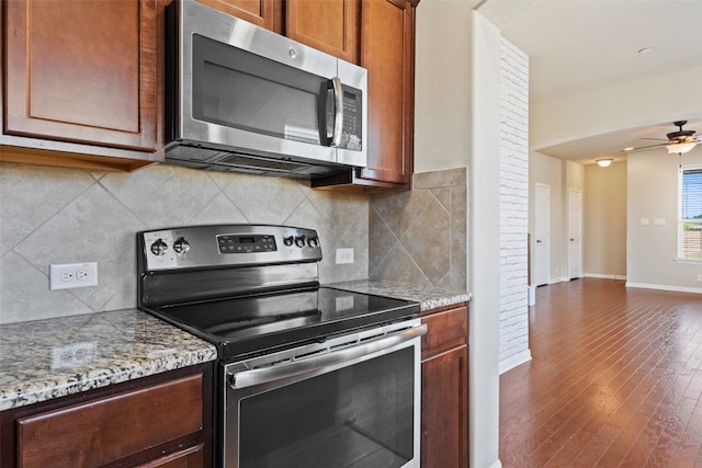 kitchen with stainless steel appliances, light stone counters, wood-type flooring, tasteful backsplash, and ceiling fan