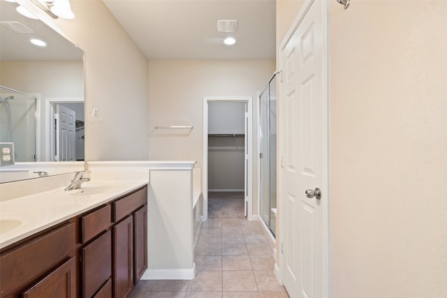 bathroom with dual sinks, tile flooring, a shower with shower door, and large vanity