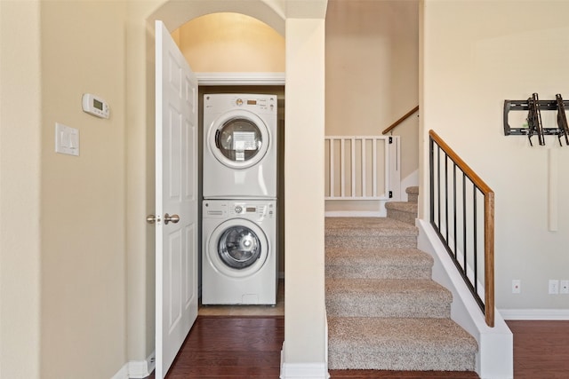 laundry room with stacked washer / dryer and dark wood-type flooring