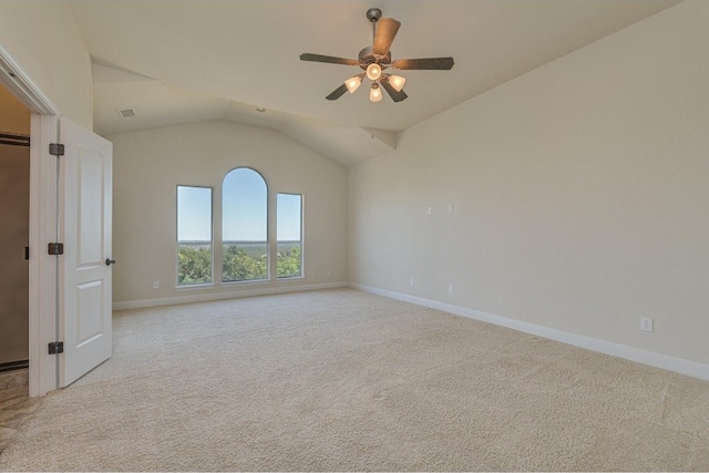 spare room with ceiling fan, light colored carpet, and vaulted ceiling