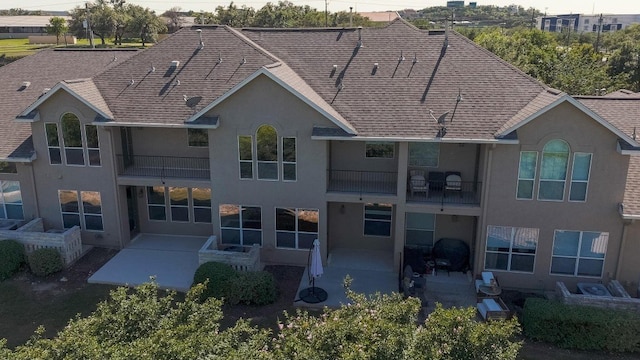 rear view of property featuring a balcony and a patio area