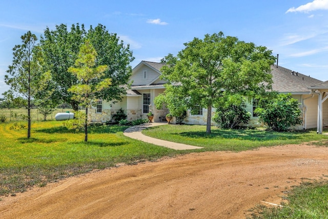 view of property hidden behind natural elements featuring a front yard