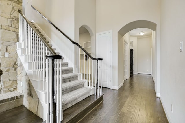 foyer entrance with a high ceiling, ornamental molding, and dark hardwood / wood-style floors