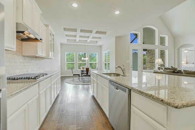 kitchen featuring wall chimney range hood, coffered ceiling, beam ceiling, appliances with stainless steel finishes, and sink