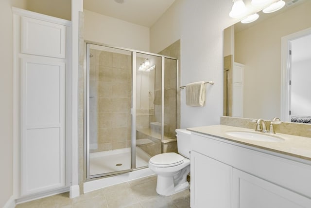 bathroom with tile floors, a shower with shower door, toilet, and vanity