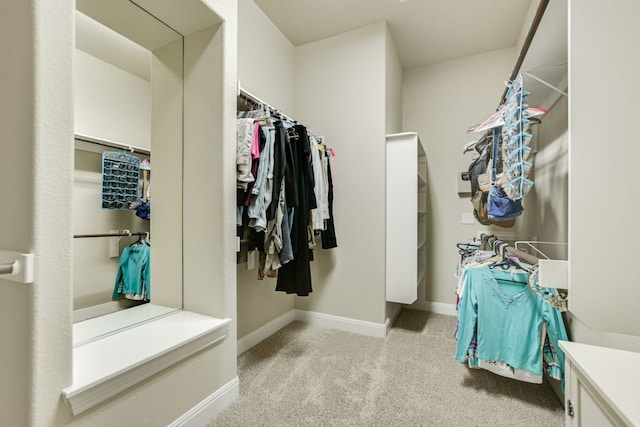 walk in closet featuring light carpet