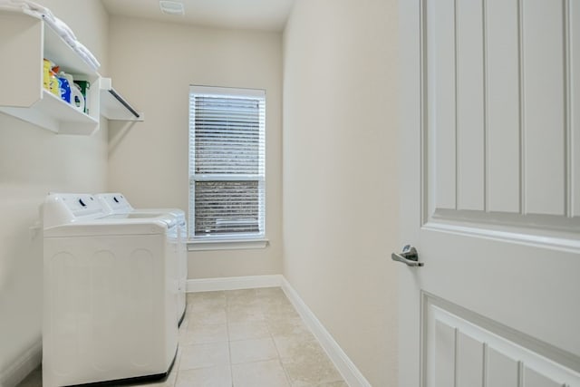 washroom with washing machine and dryer, a wealth of natural light, and light tile flooring