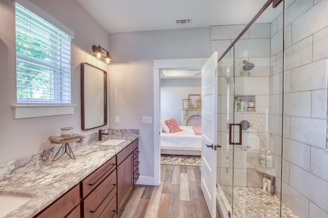 bathroom with a shower with door, vanity, and hardwood / wood-style flooring