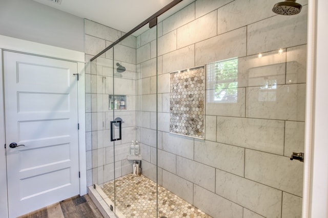 bathroom with hardwood / wood-style floors and a shower with shower door