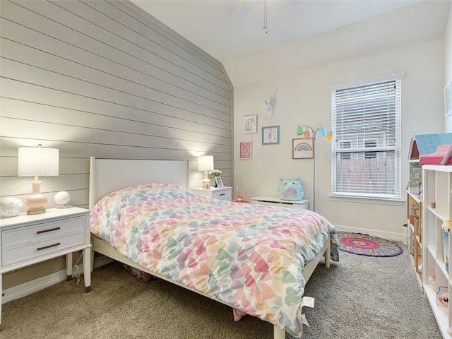 bedroom with wooden walls, vaulted ceiling, light colored carpet, and ceiling fan