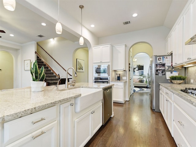 kitchen with appliances with stainless steel finishes, white cabinetry, tasteful backsplash, and sink