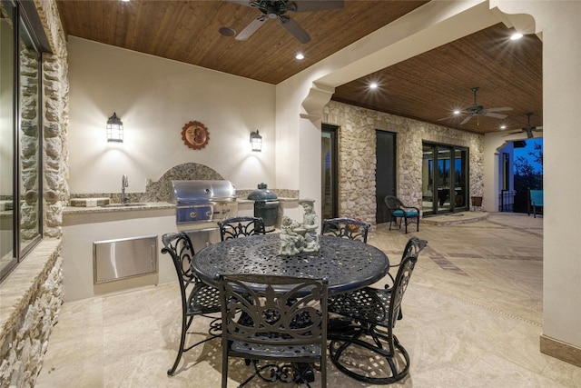 view of patio with ceiling fan, an outdoor kitchen, sink, and area for grilling