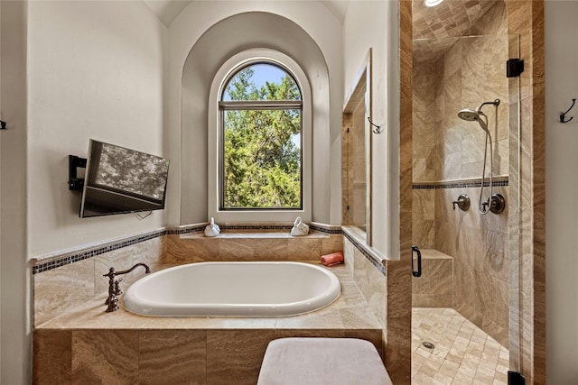 bathroom featuring shower with separate bathtub