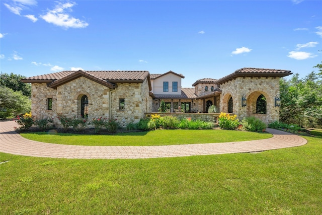 mediterranean / spanish house featuring a front lawn