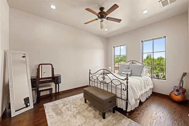 bedroom featuring ceiling fan, dark wood-type flooring, and multiple windows