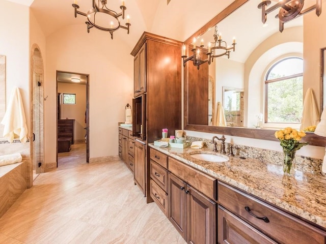 bathroom with vaulted ceiling, vanity, and an inviting chandelier