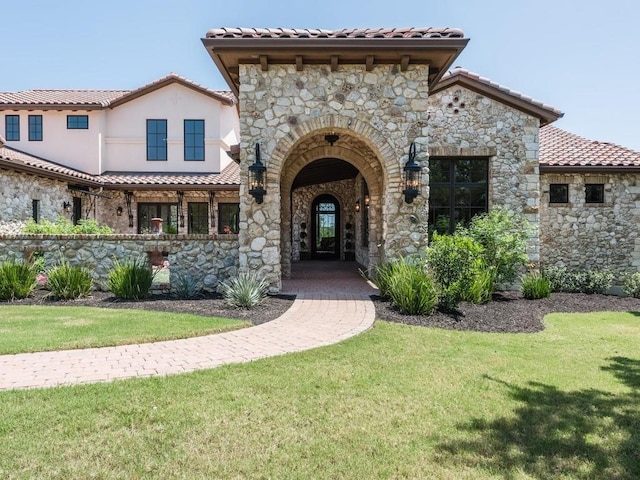 mediterranean / spanish-style house featuring a front yard