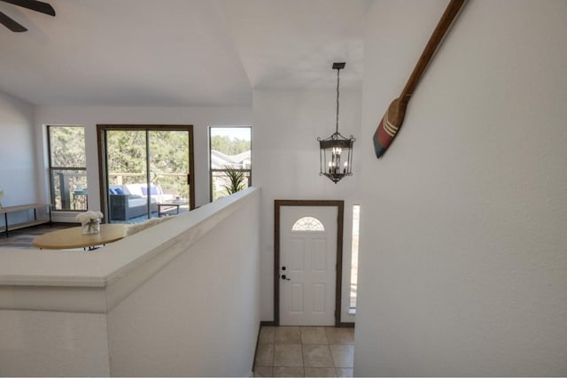 entryway with ceiling fan with notable chandelier