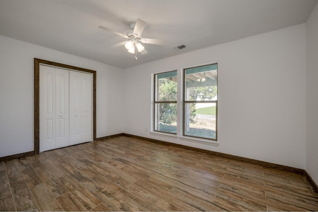 unfurnished bedroom featuring hardwood / wood-style flooring, ceiling fan, and a closet