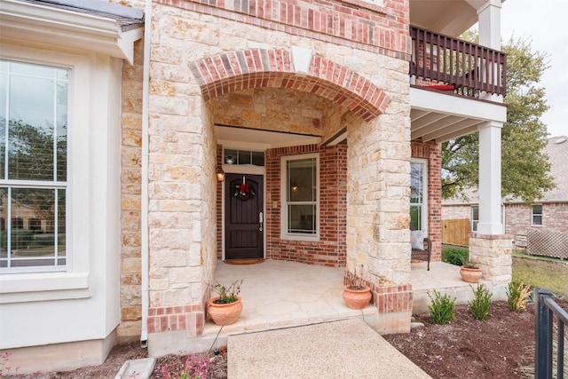 view of exterior entry with a balcony