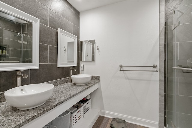 bathroom with tile walls, walk in shower, wood-type flooring, and vanity