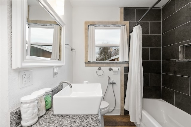 full bathroom with shower / bath combo, hardwood / wood-style floors, toilet, and sink