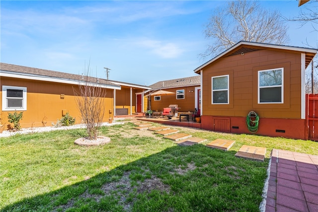 rear view of property featuring a patio area and a lawn